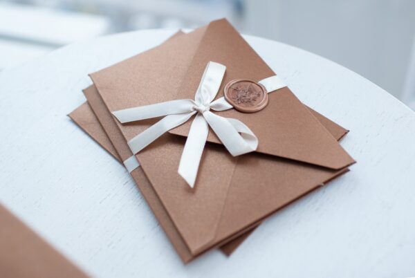 Gift Certificate, gift voucher or discount. closeup bronze invitation envelopes on white table